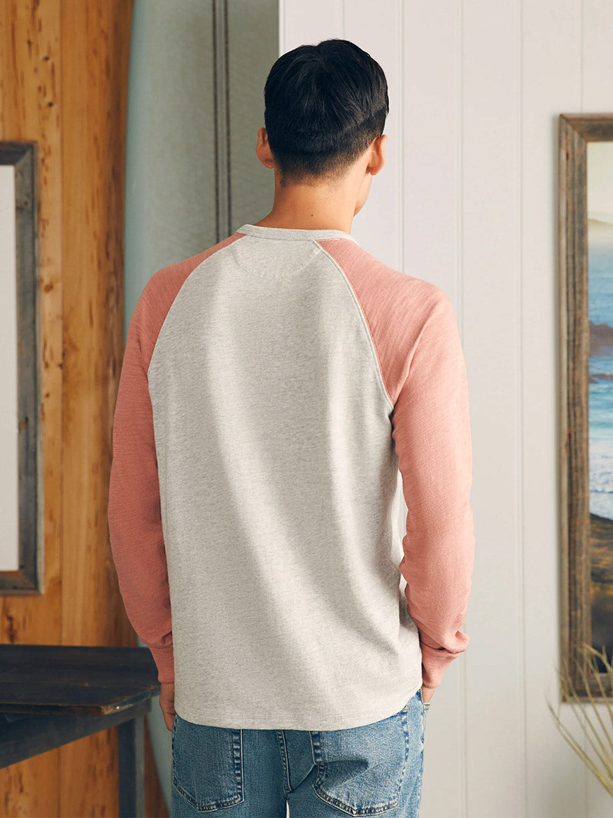 Man standing with his back to the camera wearing a Faherty Brand Sunwashed Slub Crew in Light Grey Heather Faded Flag and blue jeans.