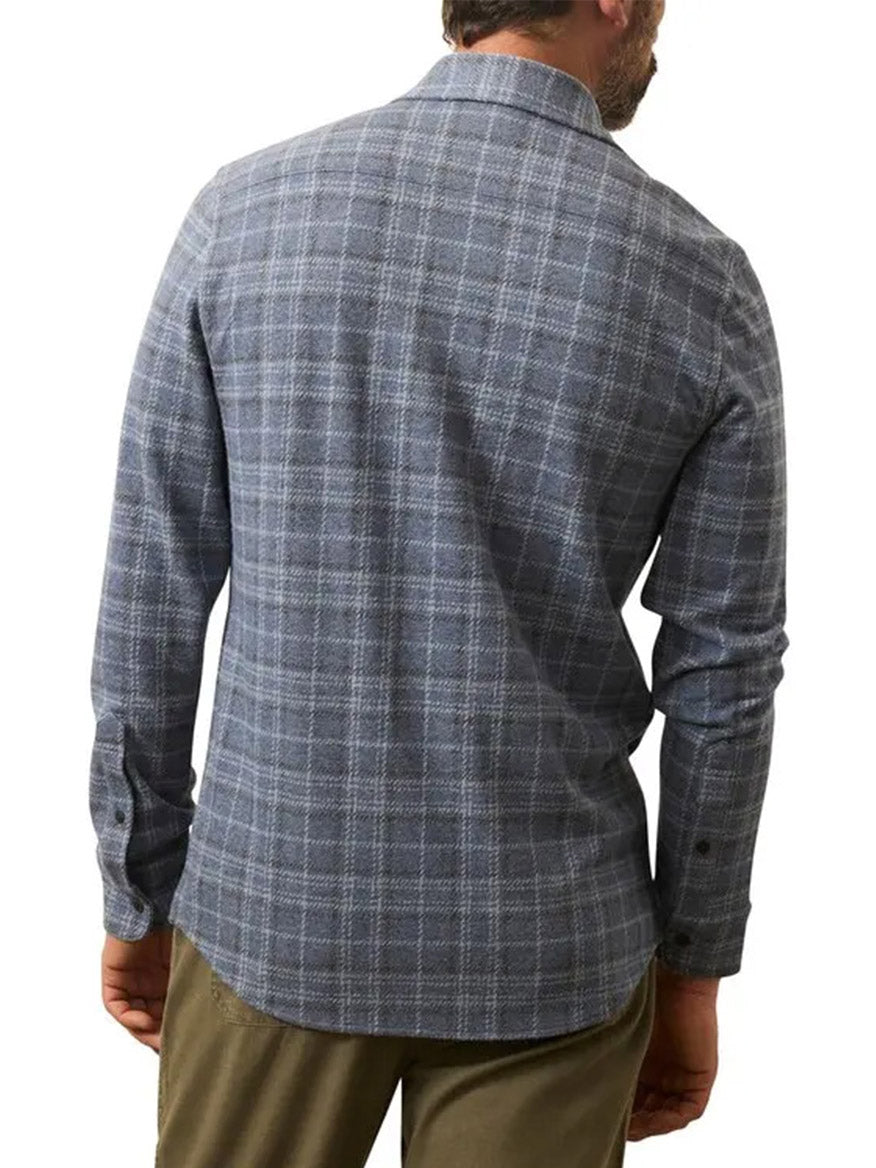 Man wearing a Faherty Brand Legend Sweater Shirt in Castle Lake Plaid, paired with khaki pants, shown from the back against a plain white background.