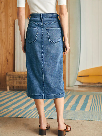 Woman wearing a Faherty Brand Stretch Terry Midi Skirt in Riverton Wash with back pockets standing in a room with wooden accents.