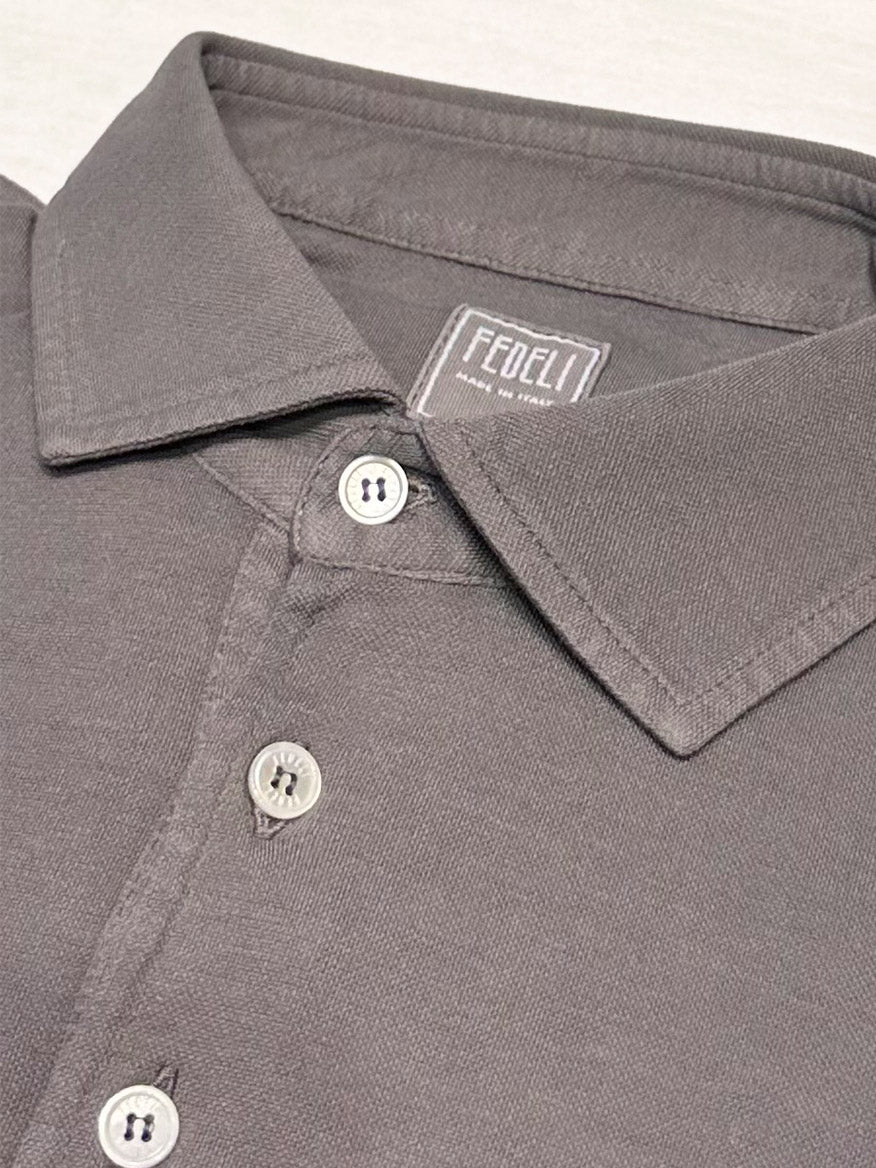 A close-up of the Fedeli Zero Superlight Pique Short Sleeve Polo in Grey shows white buttons and a FEDELI label inside the collar—showcasing refined Italian craftsmanship.