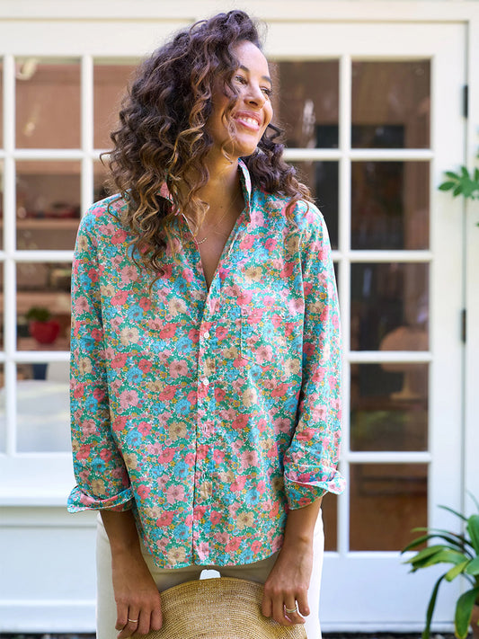 Woman smiling in a Frank & Eileen Eileen Relaxed Button-Up Shirt in Pink & Blue Floral, standing in front of a window.