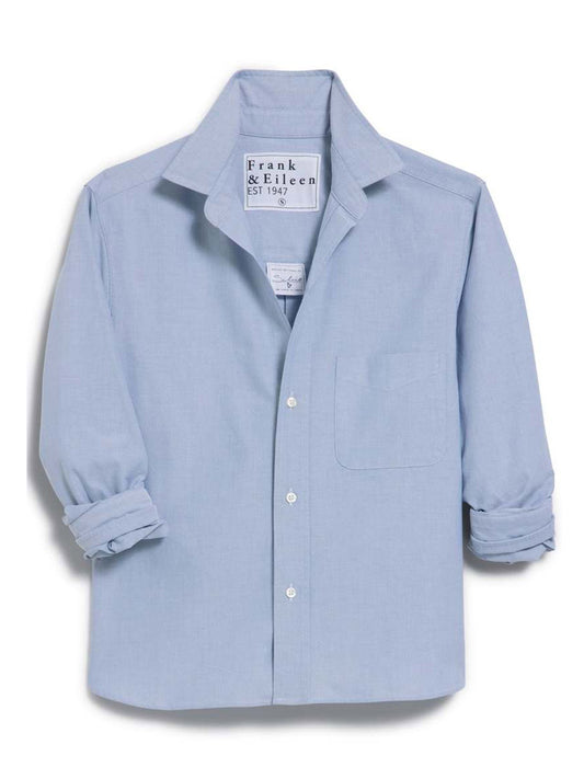 The Frank & Eileen Silvio Untuckable Button-Up Shirt in Indigo Oxford features long sleeves, a chest pocket, a collar, and stylish button placement. Shown with rolled sleeves against a white background.