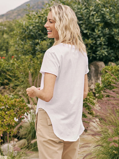 A smiling woman walking outdoors in a Frank & Eileen Theo Perfect Tee in White.