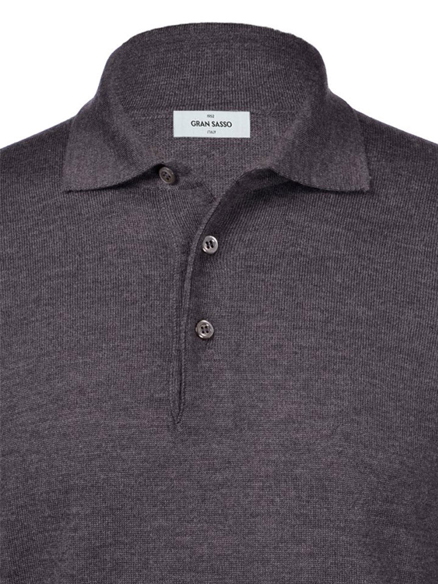 A close-up image of a folded Gran Sasso Fashion Fit Long Sleeve Polo in Charcoal, showcasing its collar and three buttons, with a label that reads "Gran Sasso." Made in Italy from luxurious Merino wool.