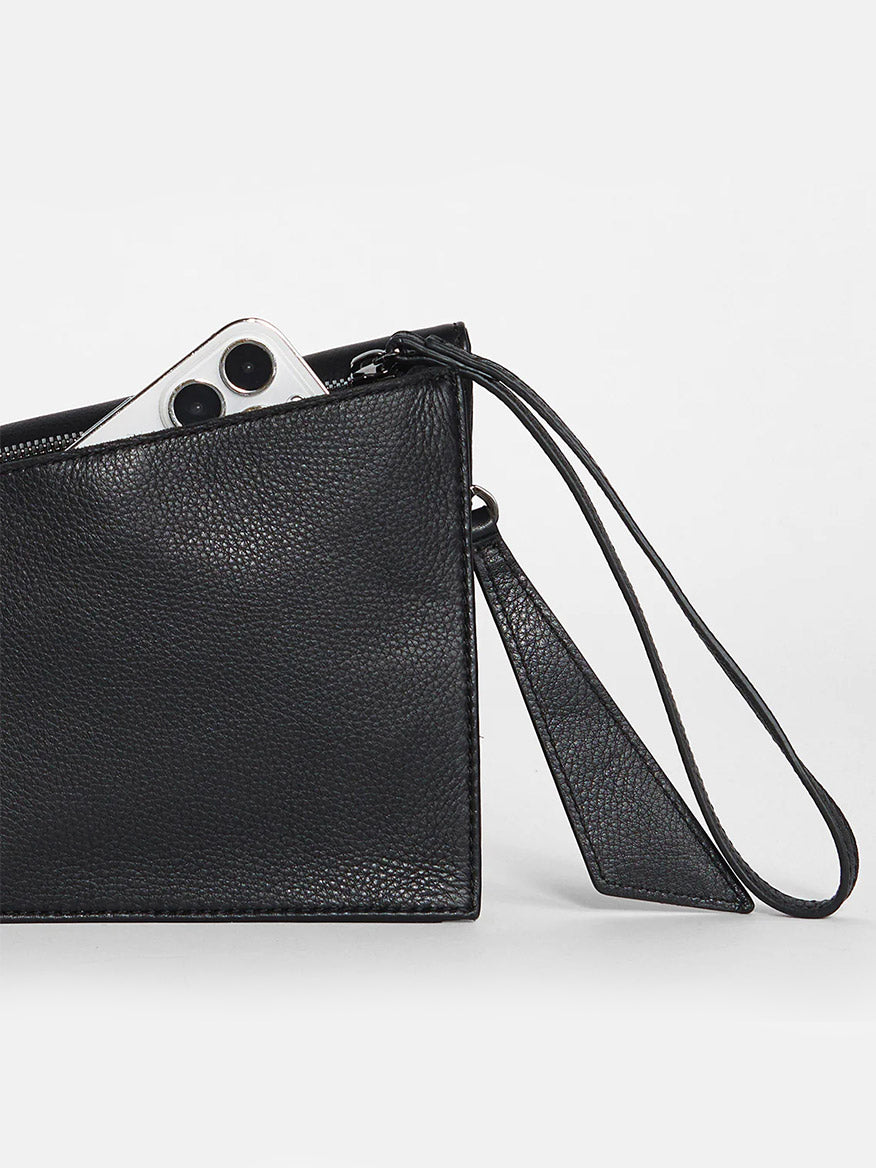 Hammitt Los Angeles Curtis in Black peeking out of a soft leather wristlet.