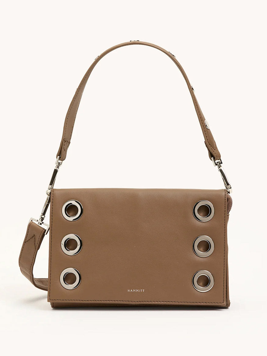 The Hammitt Los Angeles Montana Clutch Sml in Dune/Silver is a vintage-inspired brown leather handbag with a short strap and six large silver grommets on the front flap—ideal as a classic clutch accessory.