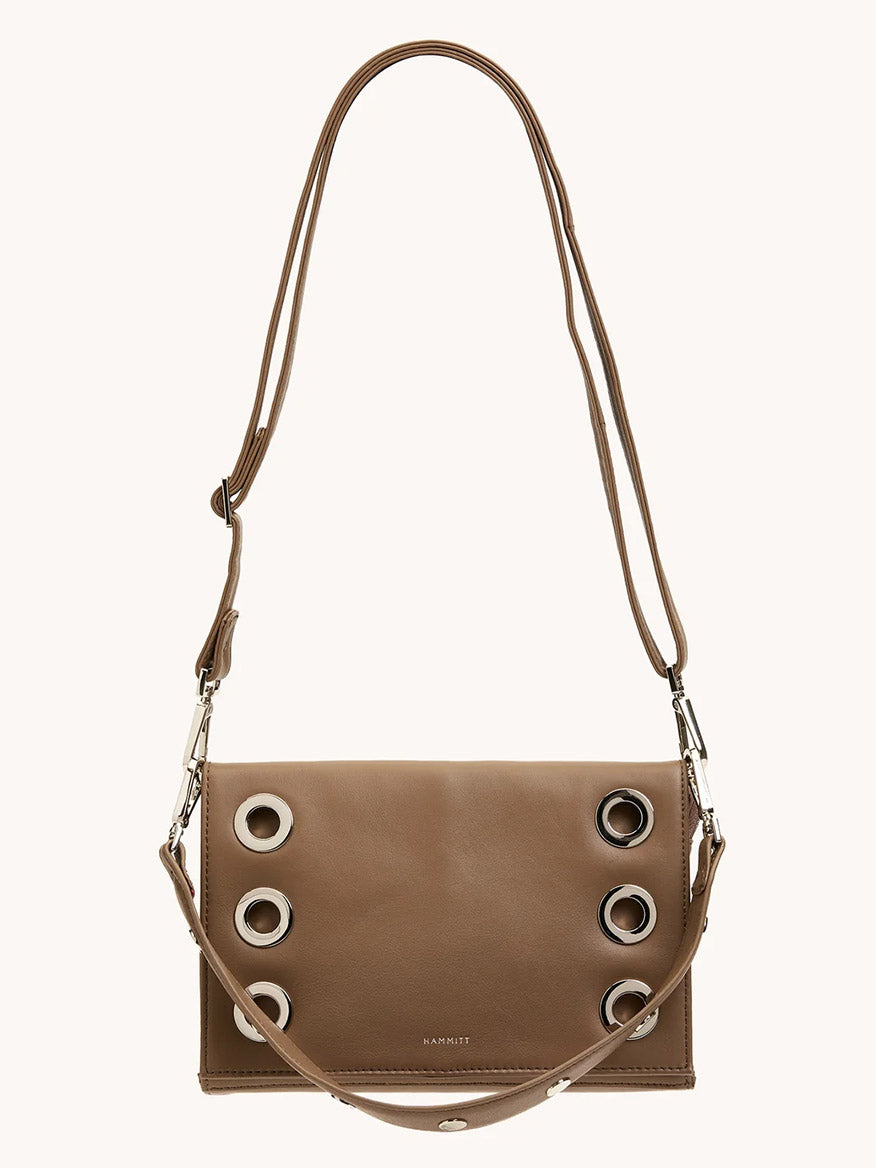 The Hammitt Los Angeles Montana Clutch Sml in Dune/Silver is a vintage-style brown leather crossbody bag with silver grommet details and an adjustable strap, shown against a plain light background.