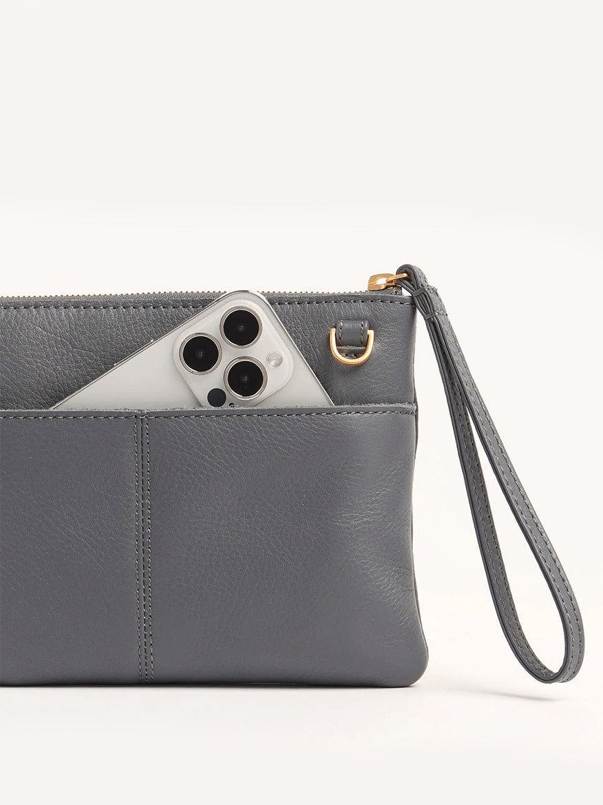 A gray pebbled leather wristlet pouch with a zipper, shown with a smartphone in its front pocket—versatile as the Hammitt Los Angeles Nash Small Clutch in Sonnet Grey/Brushed Gold.