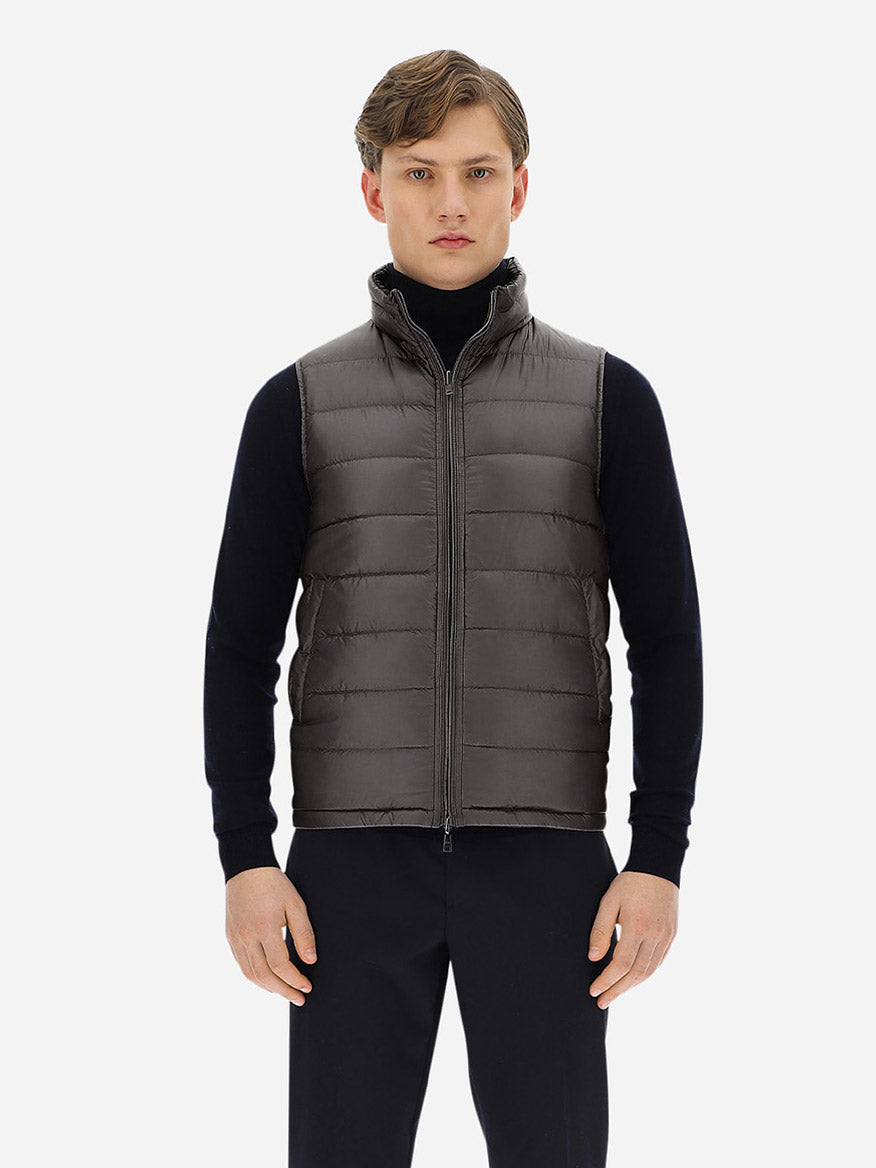 A man wearing a Herno Reversible Nylon Ultralight Waistcoat in Navy/Grey with goose down feathers.