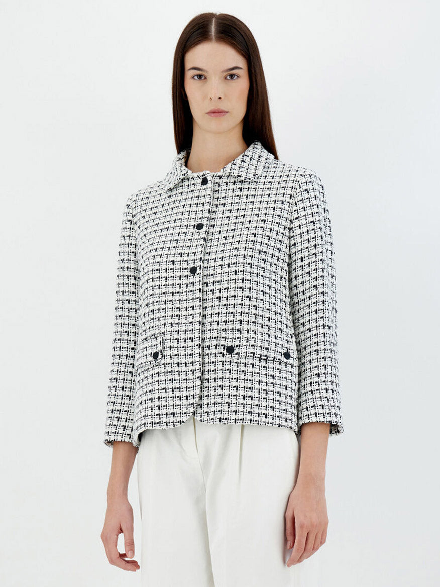 A woman wearing a Herno Trend Tweed Jacket in White and white pants against a plain white background.