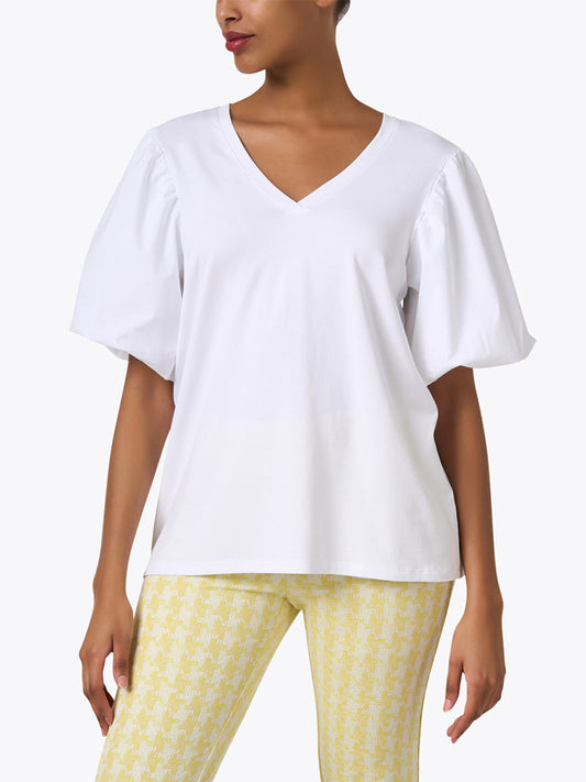 A woman wearing a Hinson Wu Kaitlyn Top in White with balloon sleeves paired with yellow patterned leggings.