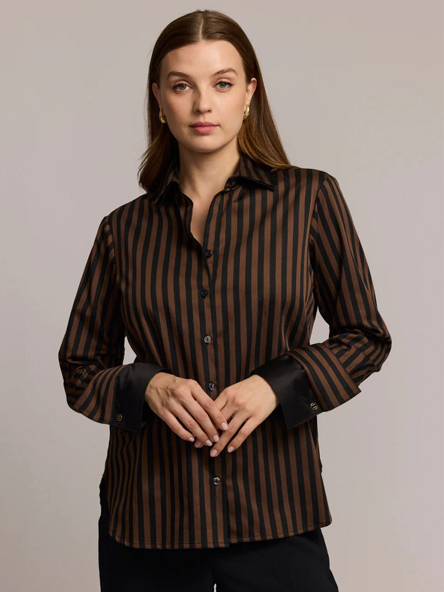 A woman stands facing the camera with hands lightly clasped, showcasing the Hinson Wu Margot Long Sleeve Lace Print shirt in Caramel/Black and its breathable fabric.