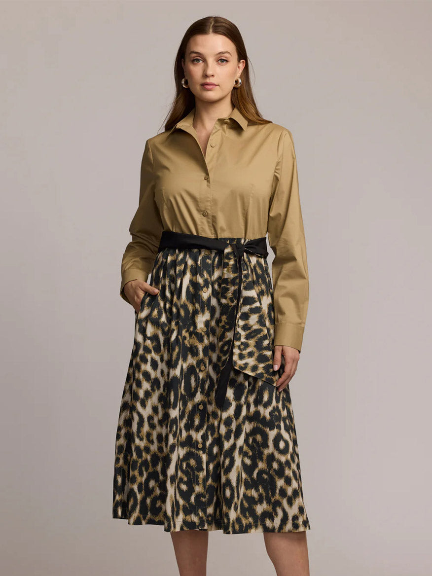A woman stands facing forward, wearing the Hinson Wu Robin Long Sleeve Animal Print Dress in khaki, a knee-length dress featuring a belted waist and premium cotton leopard print fabric.