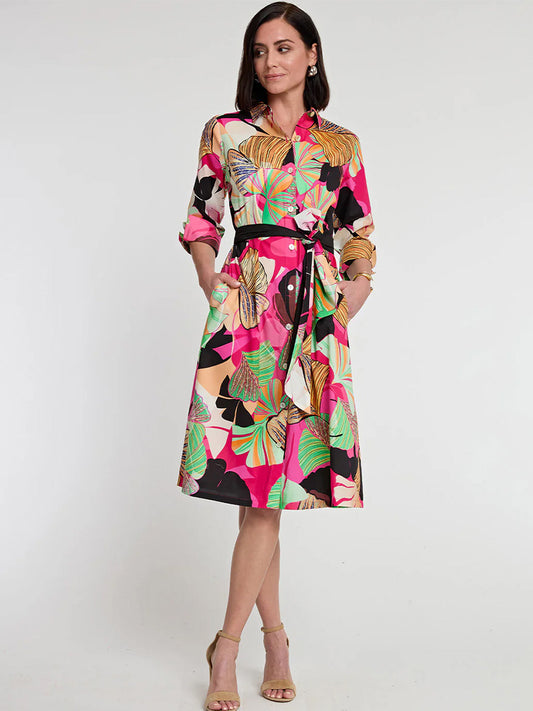 A woman stands wearing a colorful, Hinson Wu Tamron 3/4 Sleeve Dress in Gingko Print midi dress with long sleeves and a cinched waist, paired with tan heeled sandals.
