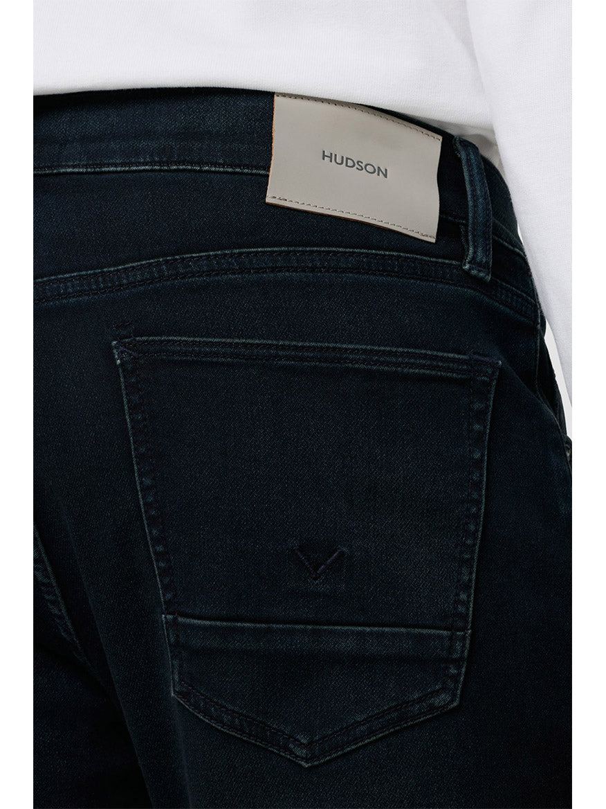 Close-up of the back pocket of Hudson Blake Slim Straight Jeans featuring a leather brand patch and premium comfort stretch denim in dark indigo Hayworth wash.