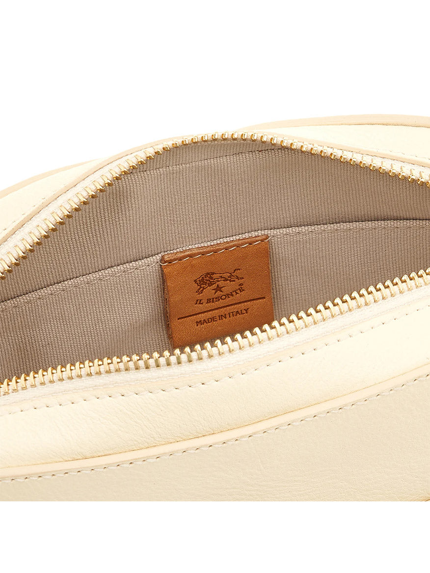 Close-up of the Il Bisonte Elisa Crossbody in white cowhide leather, shown open to reveal beige fabric lining and an interior brown "Il Bisonte Made in Italy" label.