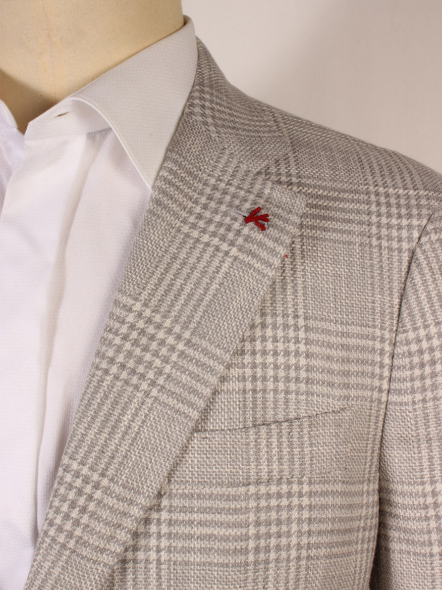 Close-up of an Isaia Capri Sport Jacket in cream Glenn plaid, made in a luxurious wool/silk blend with a red pin on the lapel. Paired with a crisp white shirt, it's crafted in Italy for an exquisite touch.