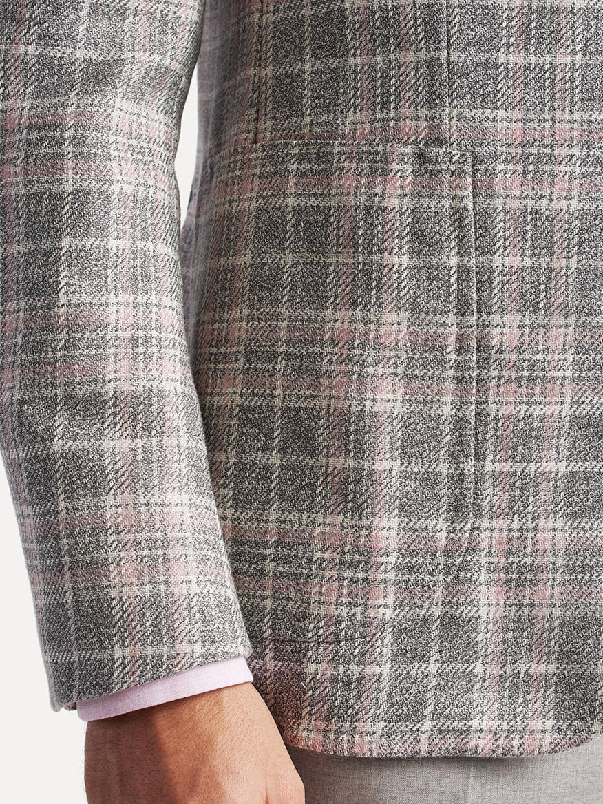Close-up of a person wearing a gray plaid Isaia Capri Sport Jacket in Rustic Grey with Cream/Pink Plaid with a pink shirt cuff visible.