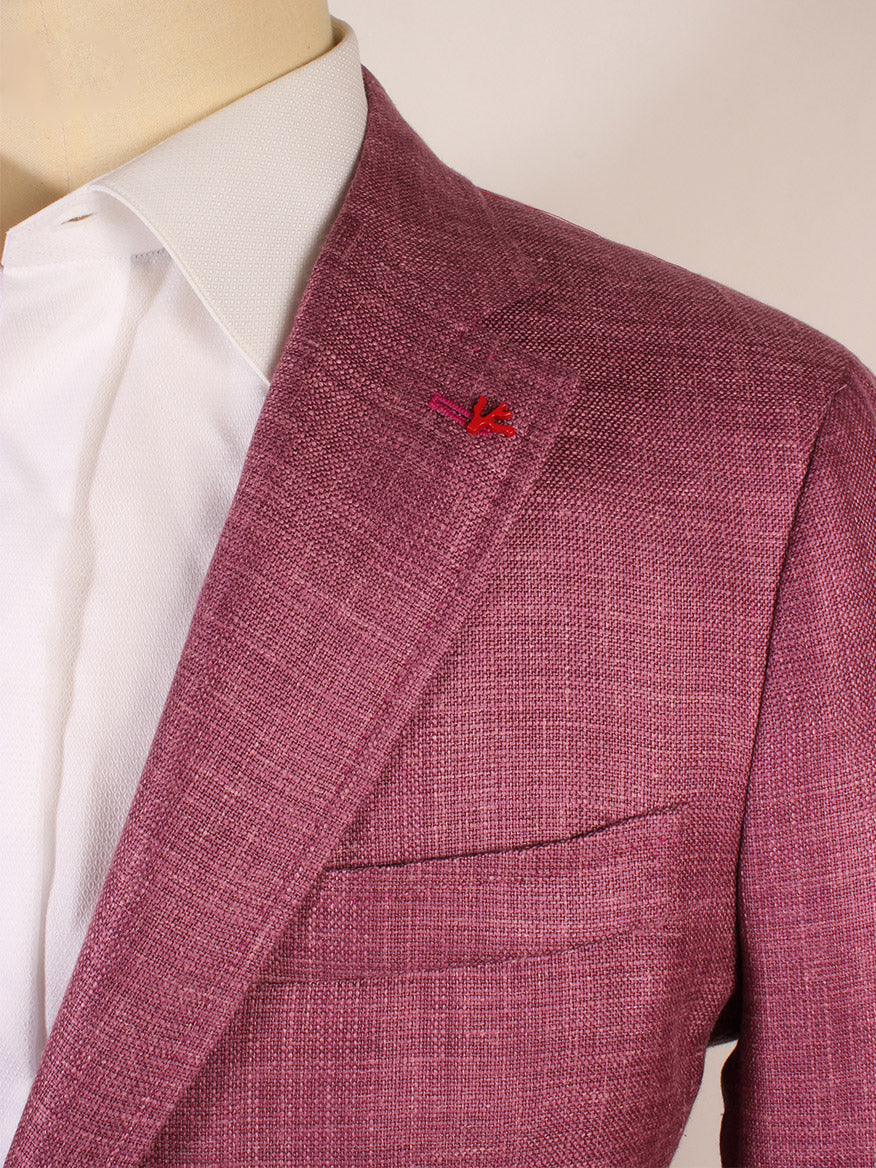A close-up of a person wearing the Isaia Capri Sport Jacket in Berry, a textured pink silk/wool blend made in Italy, layered over a white dress shirt. The image highlights the lapel, pocket, and collar details.