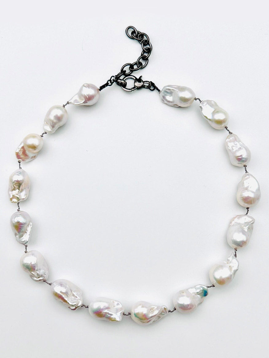 JMNYC Designs 18" AA Medium-Large White Freshwater Baroque Pearl Necklace, showcasing irregular white baroque pearls and finished with a sleek black adjustable chain clasp, elegantly displayed on a simple white background.