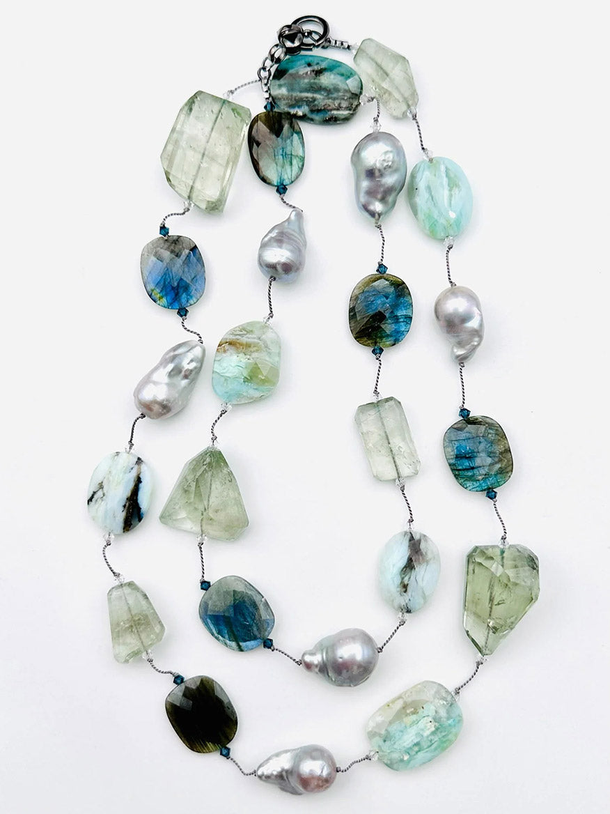 The JMNYC Designs 36" Faceted Opal, Labradorite, Green Amethyst & Grey Pearl Necklace features faceted opal, labradorite, and green amethyst stones alongside grey pearls, all elegantly strung on a thin wire with a metal clasp.