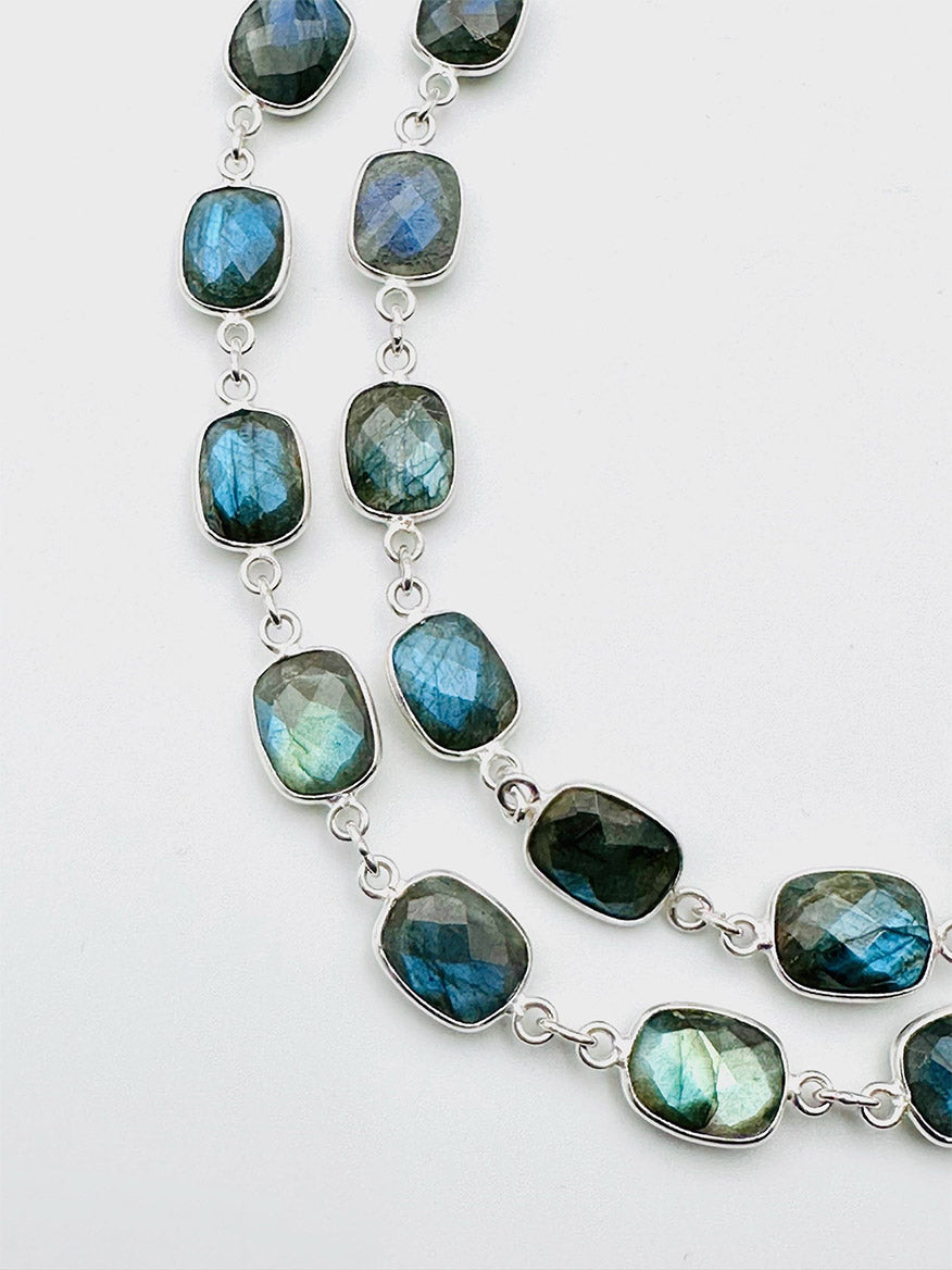 The JMNYC Designs 36" Rectangular Labradorite with Rhodium Bezel and Clasp features two strands of faceted, rectangular labradorite gemstones set in rhodium bezels, linked together to form an elegant necklace displayed against a plain white background.