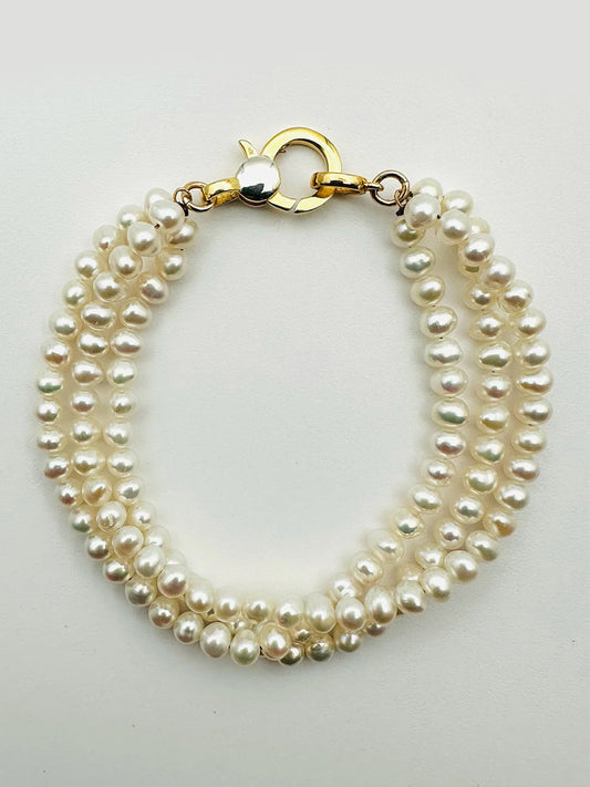 JMNYC Designs 3 Strand 4mm Freshwater Pearl Bracelet features white, irregular-shaped pearls in parallel rows with a gold vermeil clasp, displayed on a plain background.
