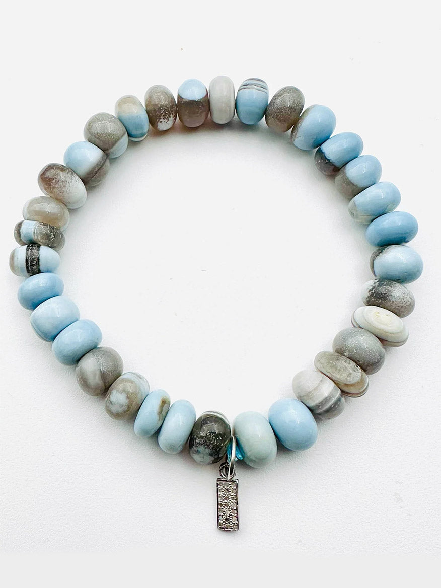 The JMNYC Designs Smooth Peruvian Blue Opal Rondelle Bracelet features blue opal beads and a petite sterling silver diamond dog tag, displayed on a white background.