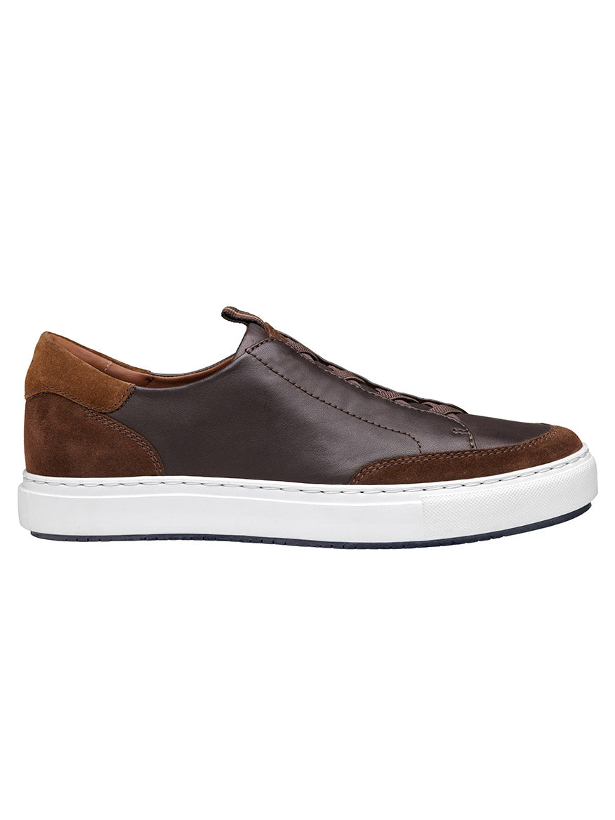 A view from the side of the J & M Collection Anson Stretch Lace-to-Toe sneaker in dark brown English suede/sheepskin, featuring a retro-style design with a white EVA outsole, brown suede accents, and dark brown laces.
