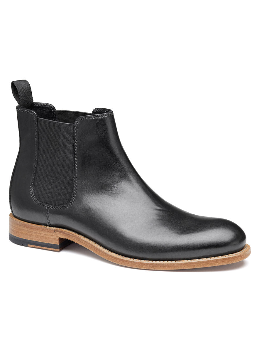 The J & M Collection Dudley Chelsea Boot in Black Dip-Dyed Calfskin is a stylish black leather boot that features elastic side panels, a back pull tab, and a light brown sole with Goodyear welt construction for enhanced durability.