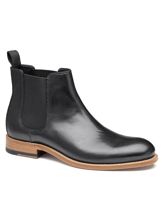 The J & M Collection Dudley Chelsea Boot in Black Dip-Dyed Calfskin is a stylish black leather boot that features elastic side panels, a back pull tab, and a light brown sole with Goodyear welt construction for enhanced durability.