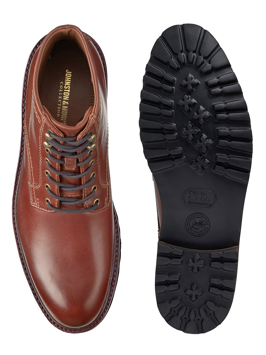 The J & M Collection Dudley Lug Plain Toe Boot in Mahogany Full Grain is depicted with one boot shown from the top and the other from the bottom. It features a textured black rubber sole and is expertly crafted with vegetable-tanned leather.