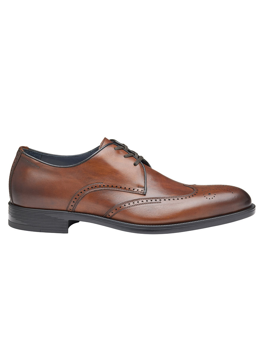 A J & M Collection Flynch Wing in Tan Italian Calfskin with brogue detailing, black laces, and a black sole, viewed from the side. Crafted from luxurious Italian calfskin with soft leather linings for added comfort.
