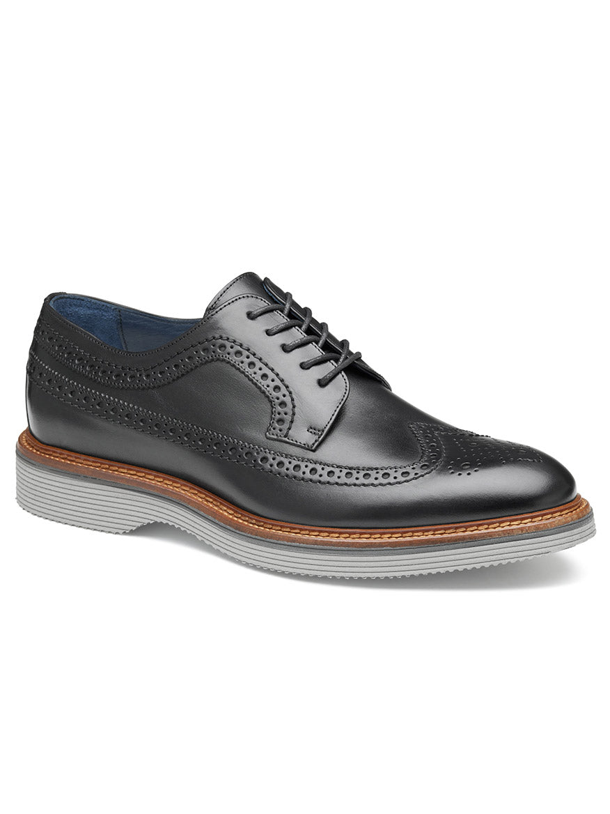 A J & M Collection Jenson Longwing in Black Italian Calfskin with decorative perforations, a brown welt, gray rubber sole, and an Italian calfskin upper, featuring a cushioned footbed for added comfort.