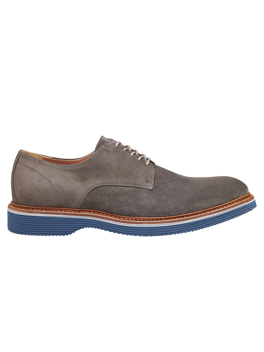 A side view of the J & M Collection Jenson Plain Toe in Grey Italian Suede, featuring brown stitching, European suede uppers, and a blue rubber sole.