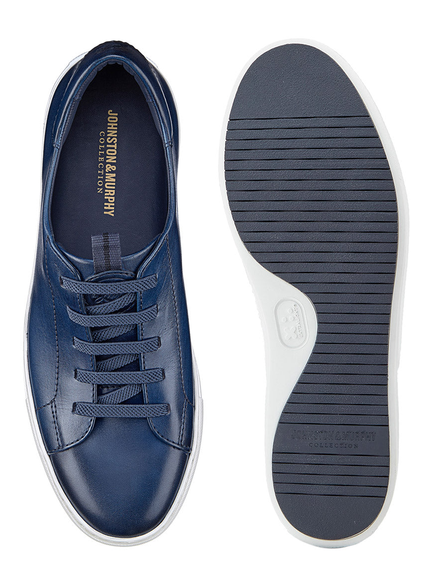 Top and sole view of the J & M Collection Anson Lace-to-Toe sneaker in navy hand-stained calfskin, featuring a flexible EVA sole. The white laces enhance its retro style, while visible branding and premium suede accents add sophistication.