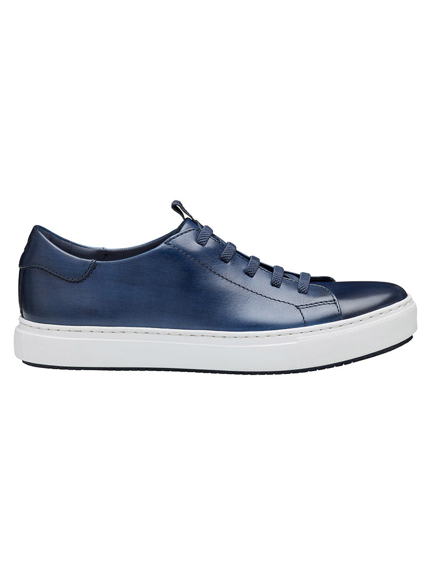 The J & M Collection Anson Lace-to-Toe in Navy Hand-Stained Calfskin is a retro-style sneaker, featuring blue leather with matching laces, a white rubber sole, and premium suede accents.