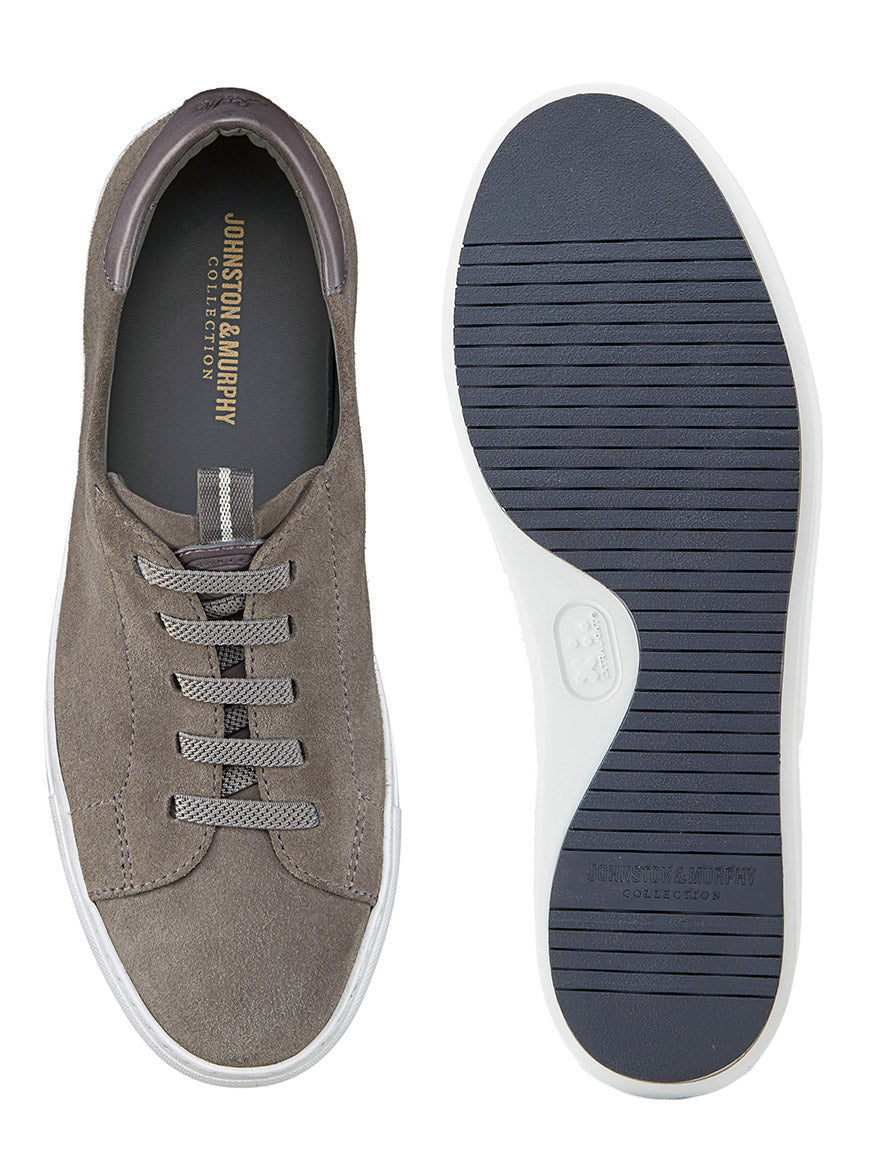 J & M Collection Anson Lace-to-Toe in Grey English Suede sneakers feature a retro-style look with brown suede, gray laces, and a white sole. The black horizontal stripes on the sole elegantly display brand details, shown from the top and side angles.