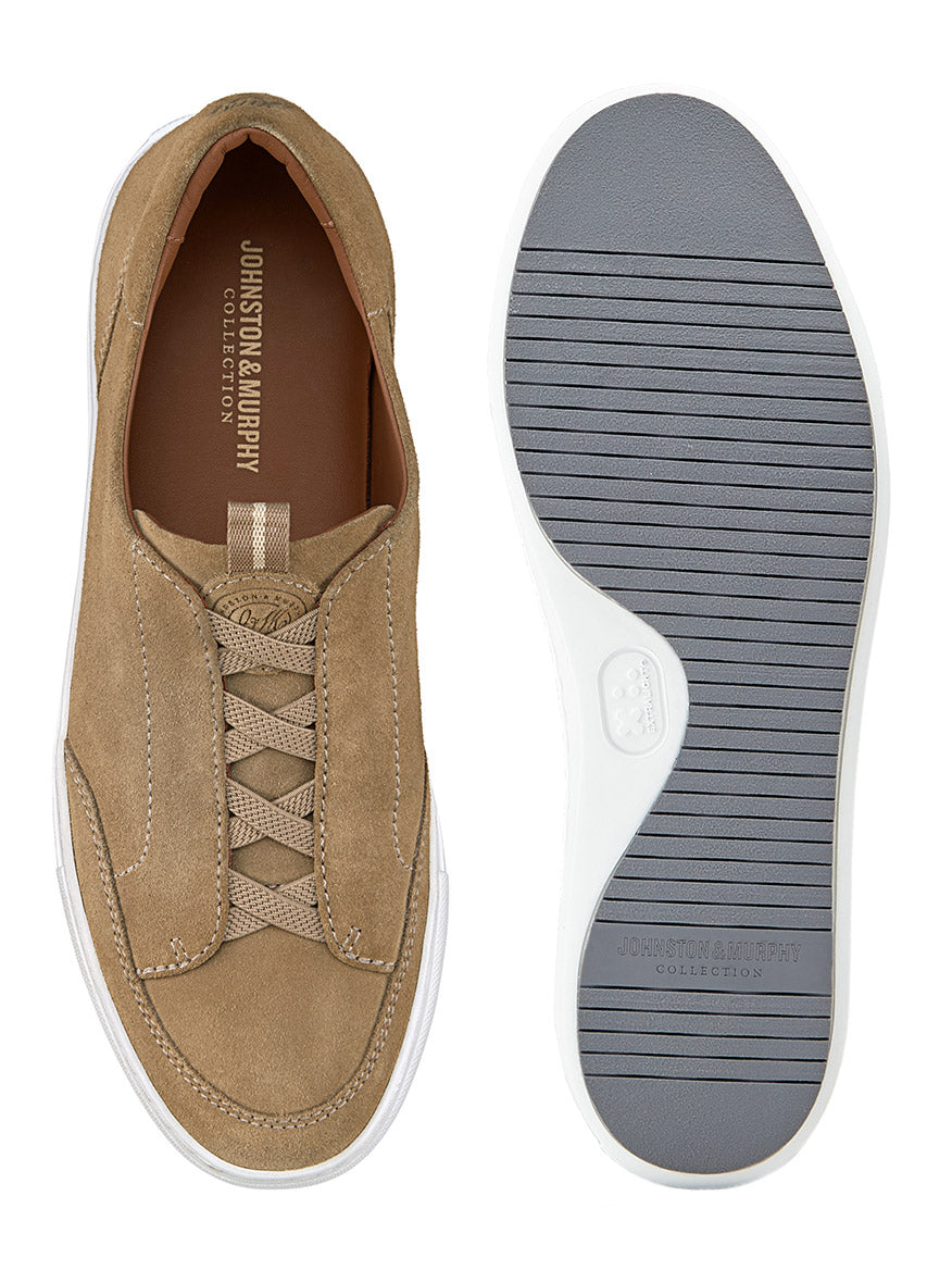 Check out the J & M Collection Anson Stretch Lace-to-Toe sneakers in Taupe English Suede. They feature a tan all-suede design with white soles, showcased from the top and bottom. The left shoe is viewed from above, while the right highlights its cushioned leather footbed with branding on the insole and sole.