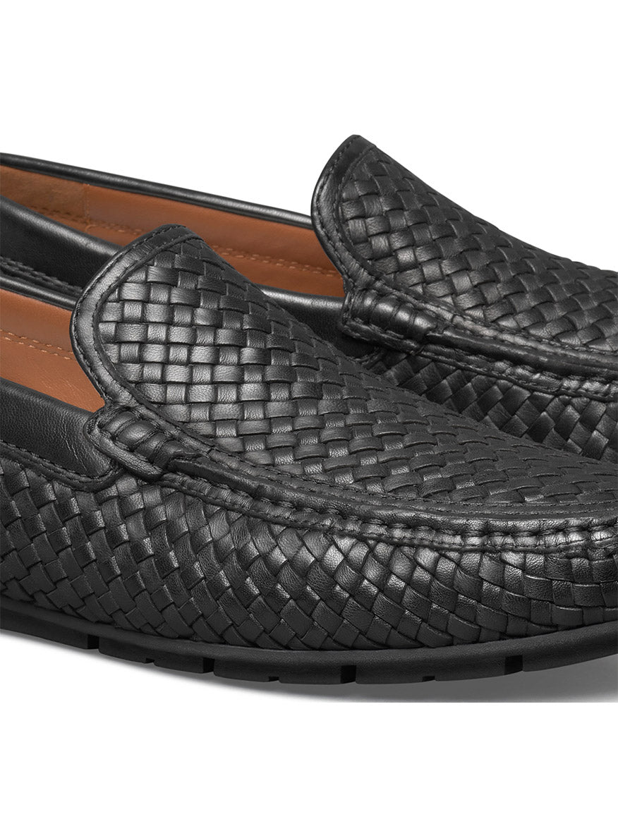 A close-up of the J & M Collection Baldwin Driver Woven Slip-On in Black Sheepskin showcases its detailed texture and stitching, complemented by a cushioned footbed for enhanced comfort.