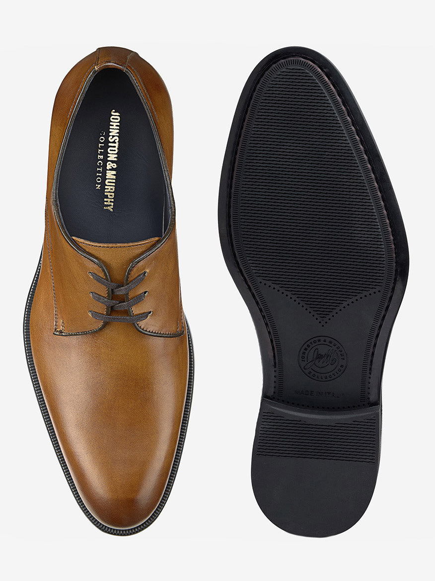 The J & M Collection Flynch Plain Toe in Tan Italian Calfskin features a brown leather design with a black sole, shown from top and bottom views. The brand "Johnston & Murphy" inside guarantees style and comfort.