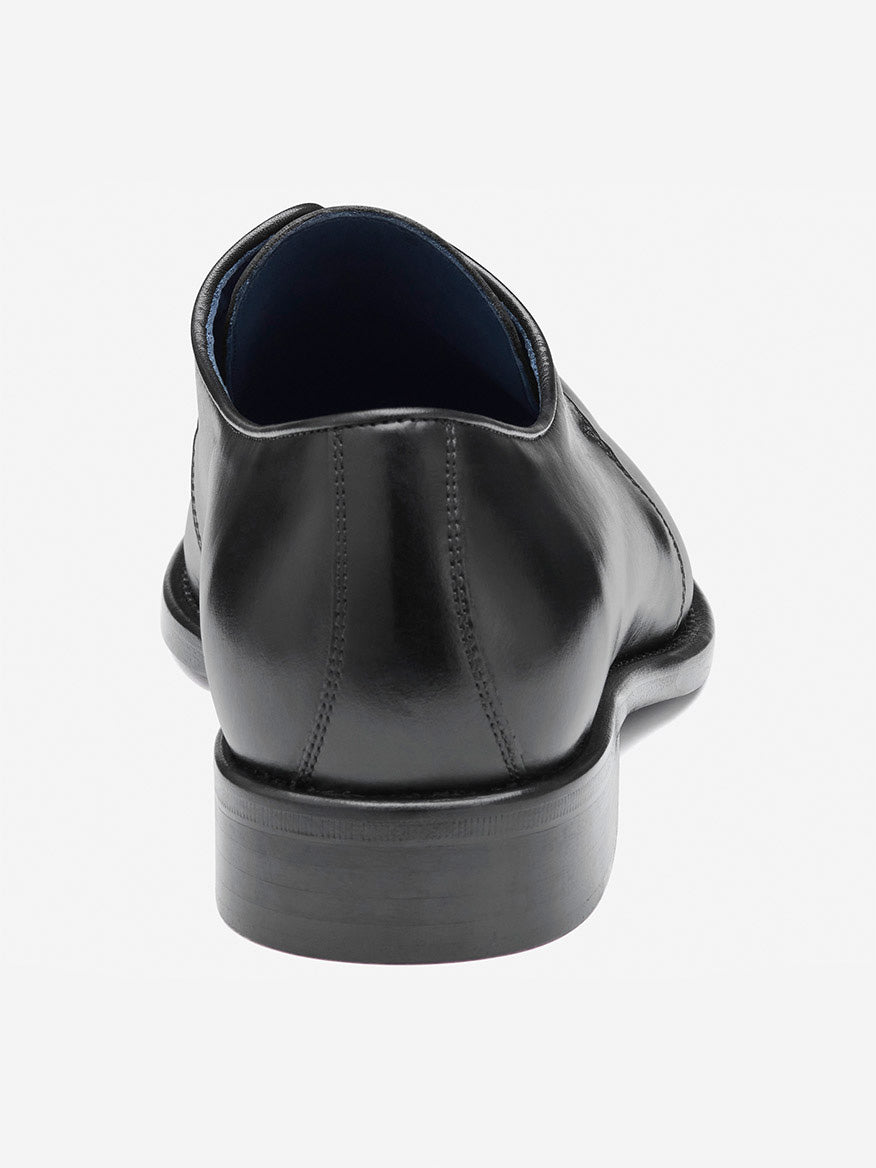 The J & M Collection Larson 2-Eye Plain Toe in Black Italian Calfskin, viewed from the back, highlights exquisite stitching and a refined heel. Handcrafted from luxurious materials, it promises elegance and style.