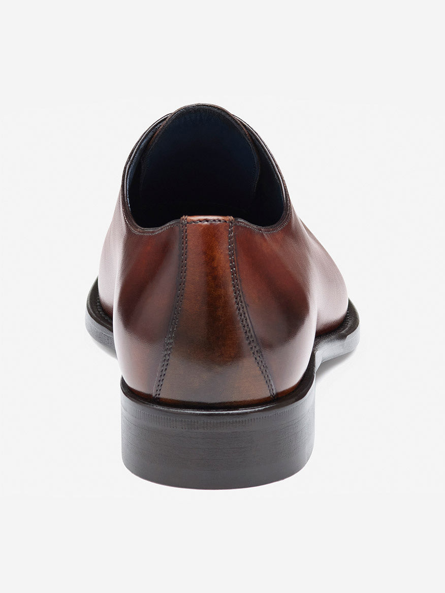 Rear view of the J & M Collection Larson Plain Toe in mahogany Italian calfskin, handcrafted with visible stitching and a flat black sole, set against a light gray background.