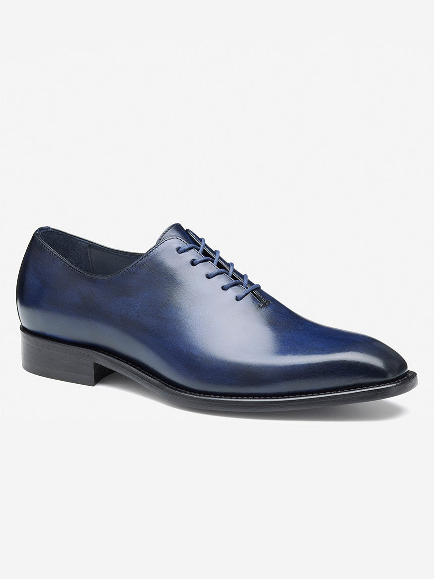 The J & M Collection Larson Plain Toe showcases a sleek design, featuring closed lacing, a low heel, and premium leather sole. Handcrafted from fine Navy Italian Calfskin, this elegant oxford shoe ensures style and comfort.
