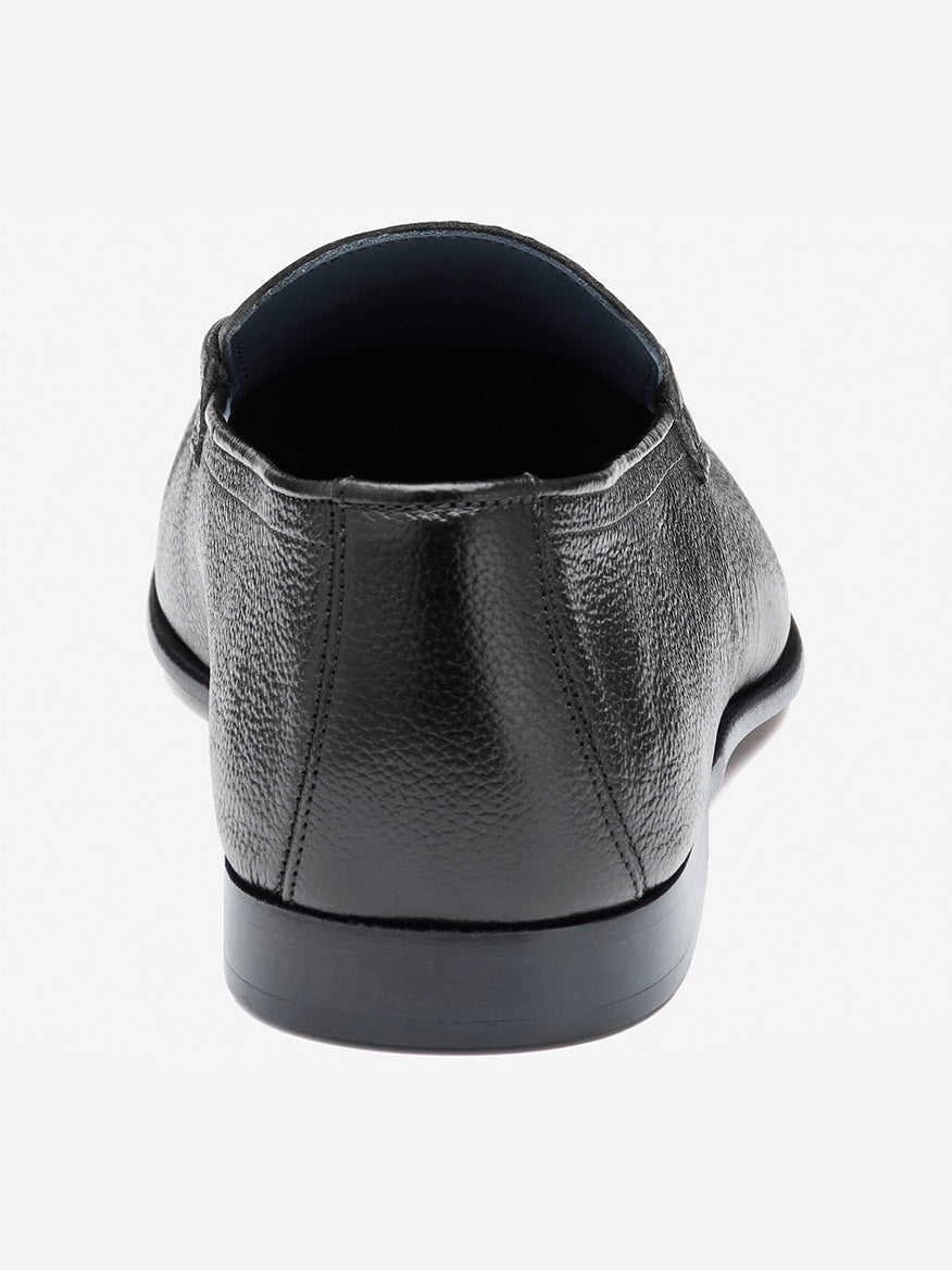 The rear view of the J & M Collection Taylor Bit black Italian calfskin dress shoe, featuring visible stitching, is shown on a light background.