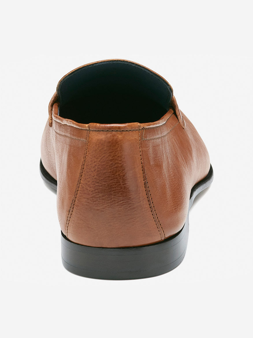 A rear view of the J & M Collection Taylor Penny in tan Italian full grain leather, highlighted by a black sole and luxurious leather-covered footbed, set against a plain light gray background.