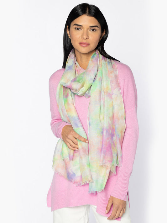 Woman wearing a pink sweater and a woven, pastel-colored Kinross Dreamscape Print Scarf in Multi.