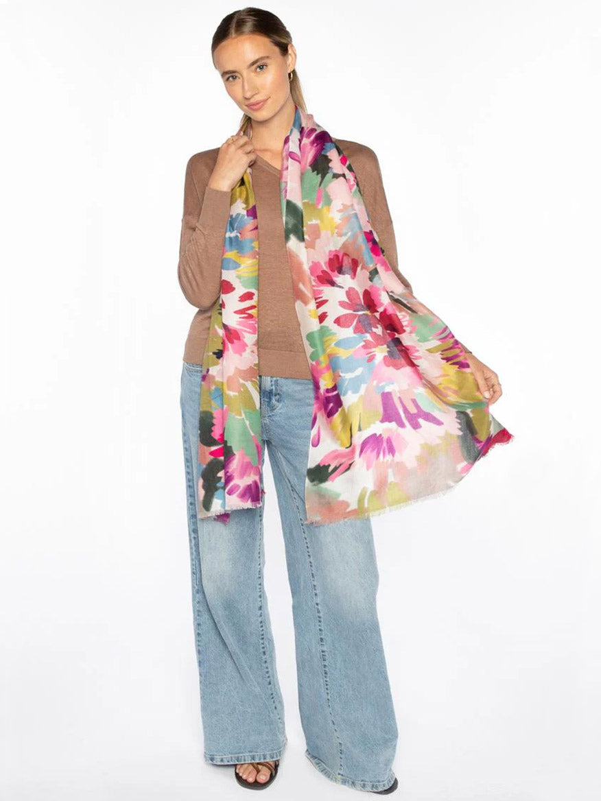 Woman wearing a brown sweater, light blue wide-leg jeans, and black sandals, styled with the Kinross Mixed Bouquet Print Scarf in Multi draped around her neck against a plain white background.
