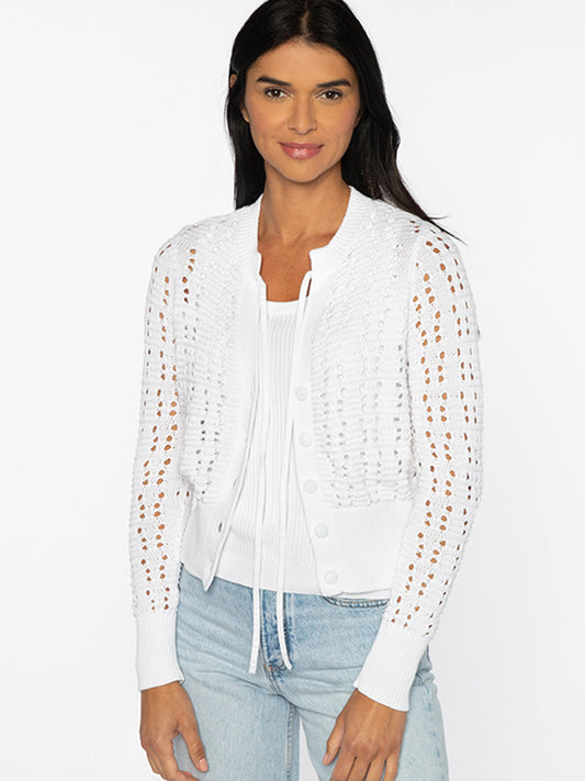 A woman wearing a Kinross Openwork Tie Cardigan in White over a simple top, paired with casual blue jeans.