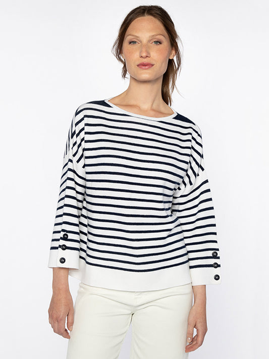 A woman wearing a Kinross Stripe Button Sleeve Pullover in White/Navy and white pants stands against a plain white background.